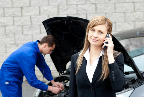 Man repairing car of business woman — Stock Photo, Image