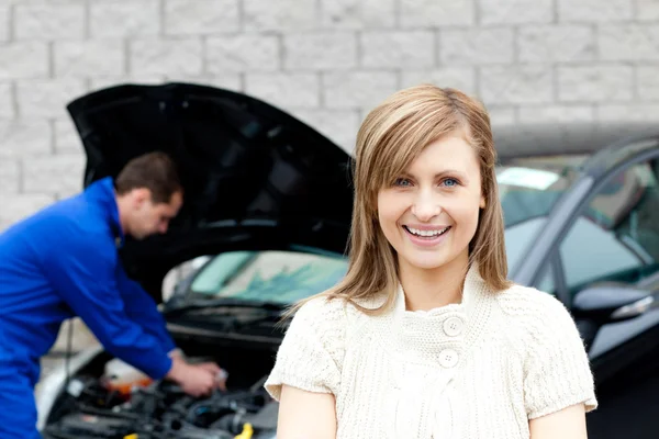 Man repairing car of smiling woman — Stock Photo, Image