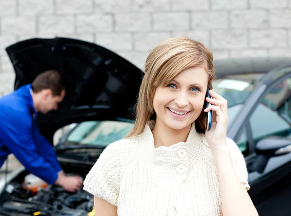 Mann repariert Auto einer telefonierenden Frau — Stockfoto