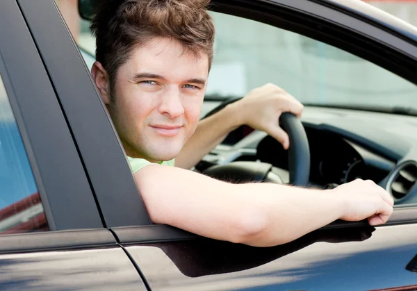 Glada unga manliga föraren sitter i sin bil — Stockfoto