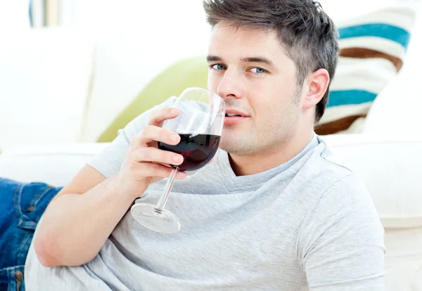 Schöner Mann auf dem Boden liegend Wein trinkend — Stockfoto