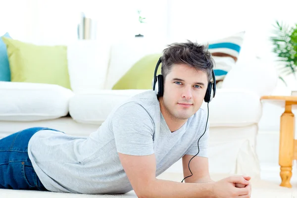 Handsome man with headphones lying on the floor — Stock Photo, Image