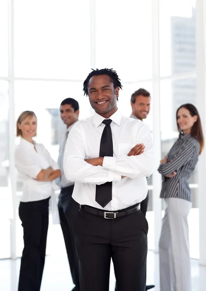 Joyful male manager standing at the camera with his team — Stock Photo, Image