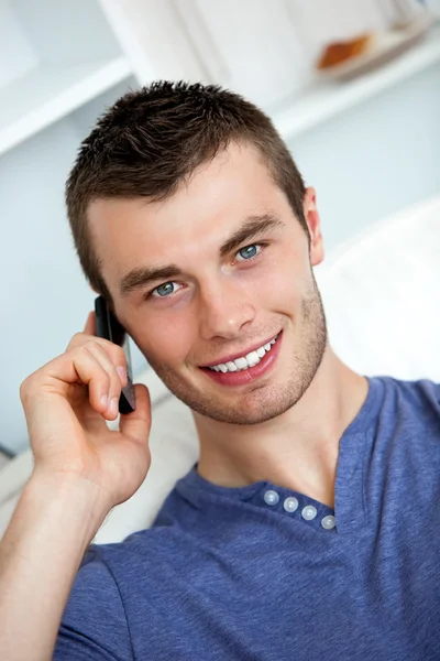 Friendly man on phone sitting on a couch Stock Photo