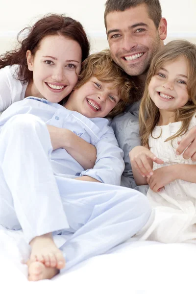 Porträt einer jungen Familie, die im Bett liegt lizenzfreie Stockbilder