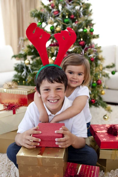 Glückliches Geschwisterpaar feiert Weihnachten Stockbild