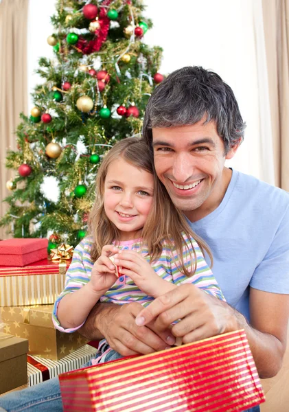Papa et petite fille jouant avec des cadeaux de Noël Image En Vente