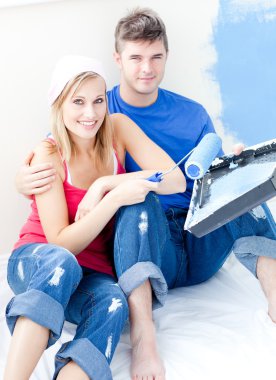 Loving couple painting a room together clipart