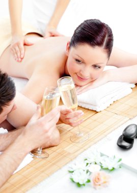 Caucasian young couple enjoying a back massage and drinking cham clipart