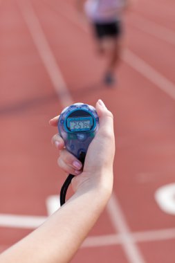 Close-up of a woman holding a chronometer to measure performance clipart