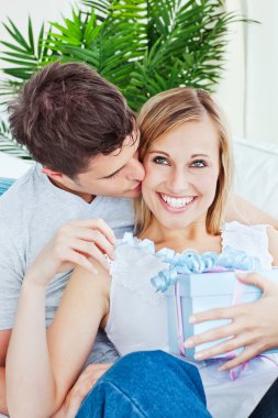 Pleased woman receive a present from her boyfriend clipart