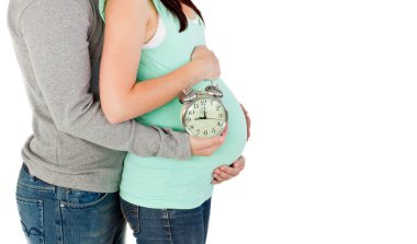 Close-up of loving future parents holding a clock clipart