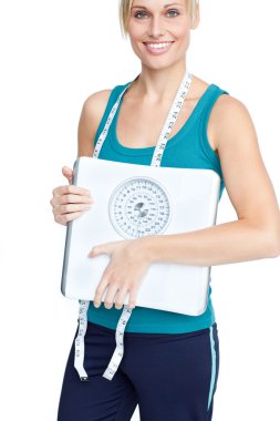 Smiling young woman holding a weight scale clipart