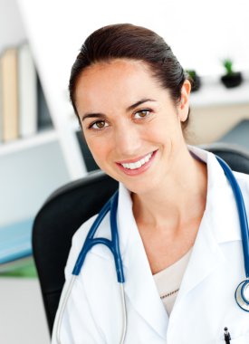 Self-assured female doctor smiling at the camera clipart