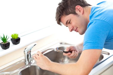 Manual man repairing a kitchen sink clipart