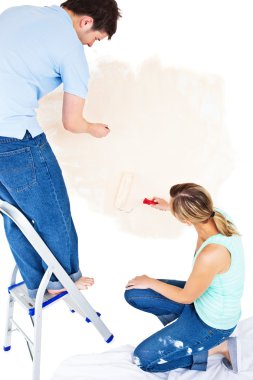 Concentrated couple painting a room clipart