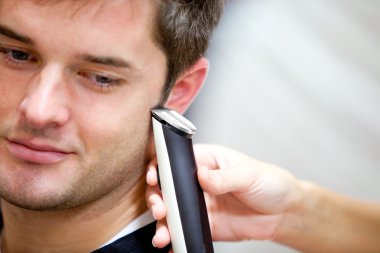 Good-looking man being shaved clipart