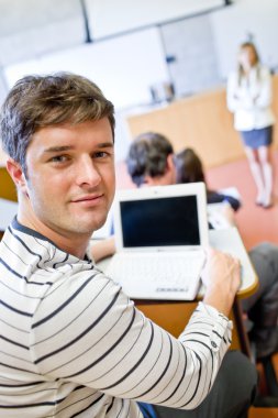 Close-up of a bright male student using a laptop during a univer clipart