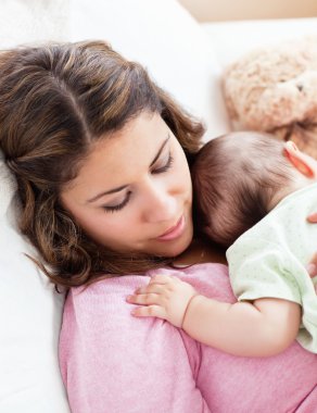 Portrait of a baby and his mother sleeping peacefully in the sof clipart