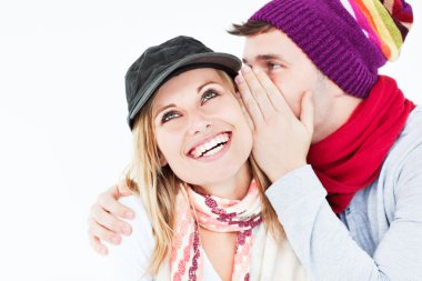 Handsome man with hat telling a secret to his laughing girlfrien clipart