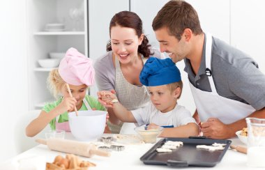 Happy family cooking a cream together in the kitchen clipart