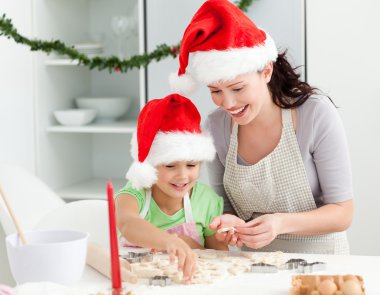 Lovely mother and daughter preparing Christmas cookies clipart