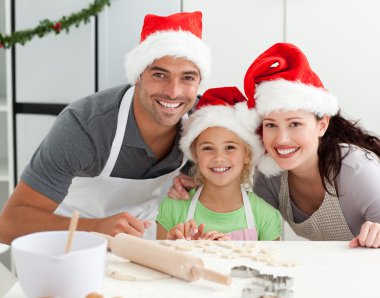 Happy family preparing Christmas cookies clipart