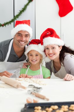 Cheerful family kneading biscuits for Christmas clipart