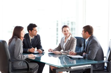 Businessmen and businesswomen talking during a meeting clipart