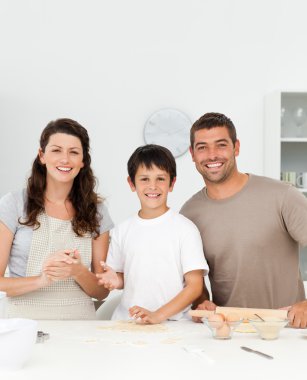 Cute boy with his parents in his kitchen clipart