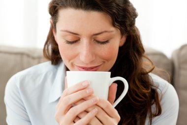 Cute businesswoman enjoying her coffee at home clipart