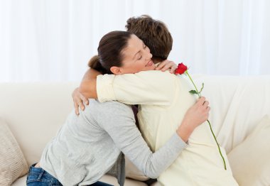 Lovely woman hugging his boyfriend after receiving a flower clipart