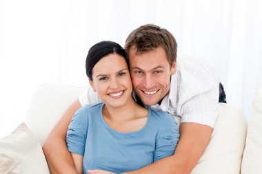 Portrait of a man hugging his girlfriend while relaxing on the s clipart