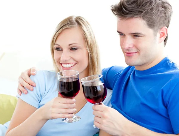 Casal afetuoso beber vinho sentado em um sofá — Fotografia de Stock