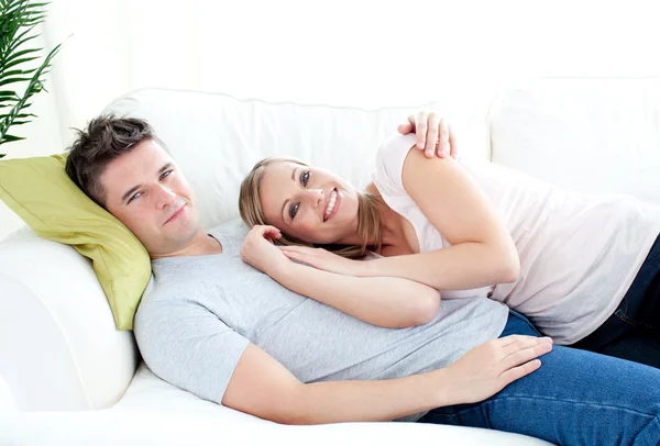 Влюбленные молодые пары lyingo вместе на диване — стоковое фото