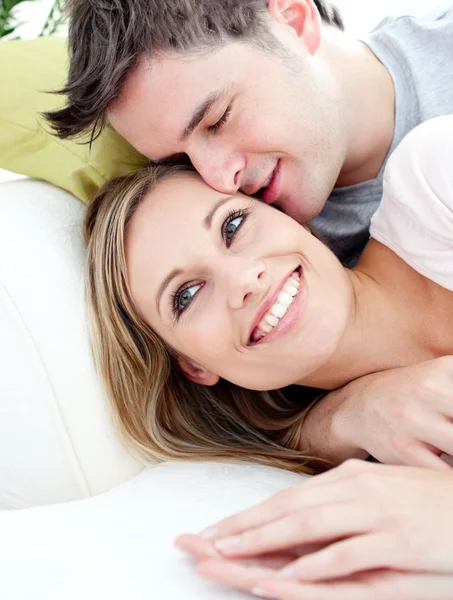 Portret van een liefdevolle vriend knuffelen zijn vriendin op de sof — Stockfoto