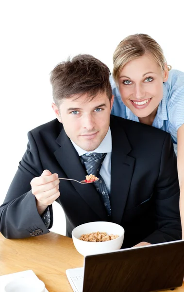Zamilovaný pár podnikatelé se usmívá na fotoaparát jíst cerea — Stock fotografie