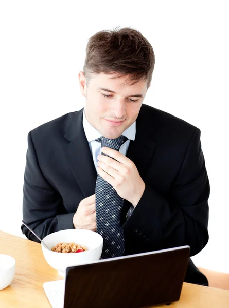 Jeune homme d'affaires attrayant faisant sa cravate en regardant son lapto — Photo