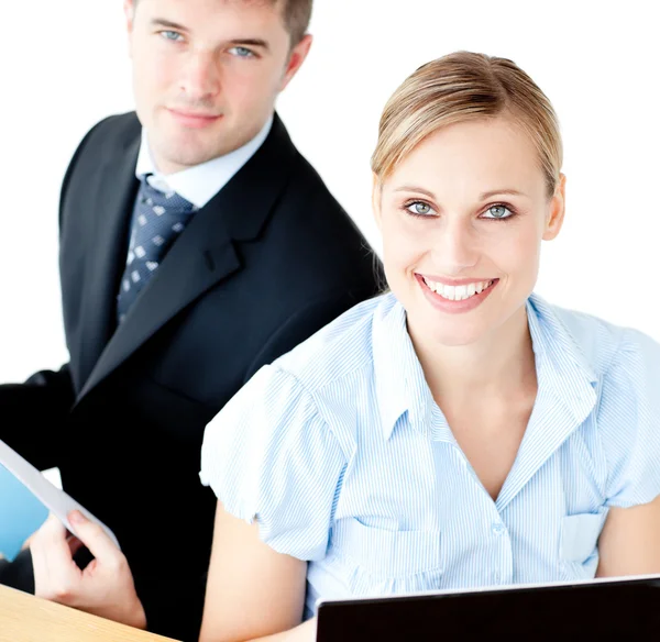 Beautiful couple of businesspeople smiling at camera using lapto — Stock Photo, Image