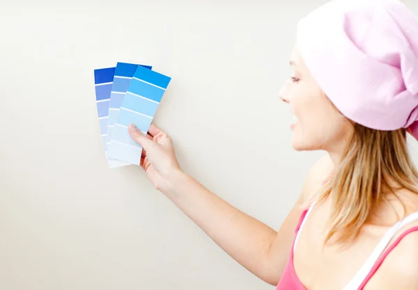 Attraktive junge Frau wählt Farbe für die Malerei eines Raumes — Stockfoto