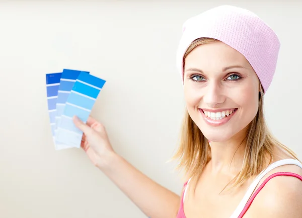 Jovem mulher alegre escolhendo cor para pintar uma sala — Fotografia de Stock