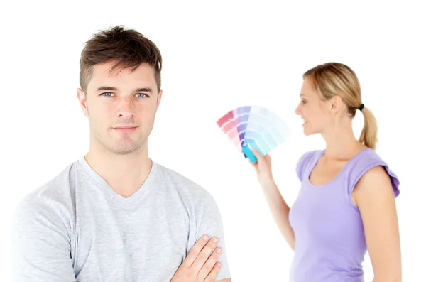 Junges kaukasisches Paar wählt Farben für die Bemalung seines Zimmers — Stockfoto