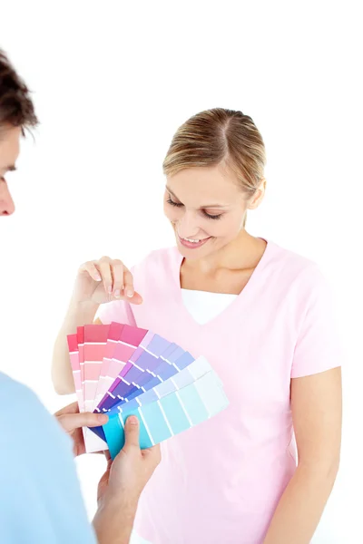 Happy young woman choosing colors for painting a room — Stock Photo, Image