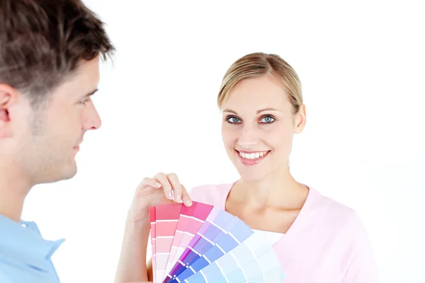 Lächelnde junge Frau, die Farben auswählt, um einen Raum zu bemalen — Stockfoto