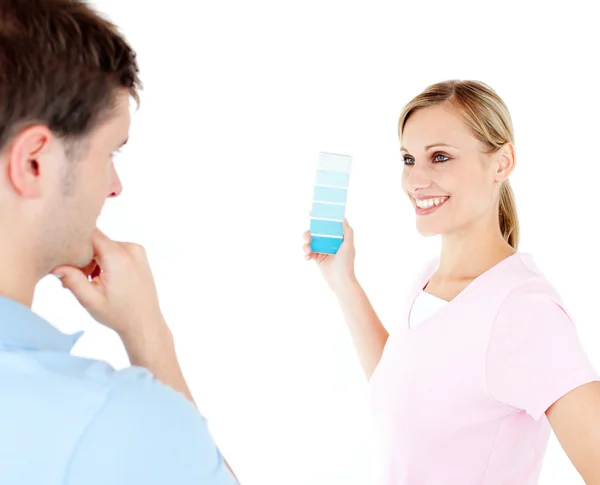 Cheerful woman showing her boyfriend colors for painting a room — Stock Photo, Image