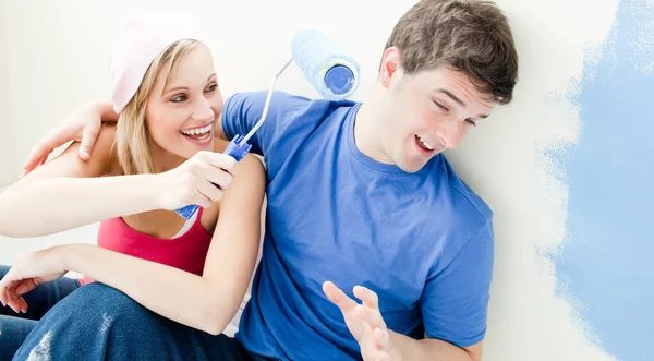 Laughing couple having fun while painting a room — Stock Photo, Image