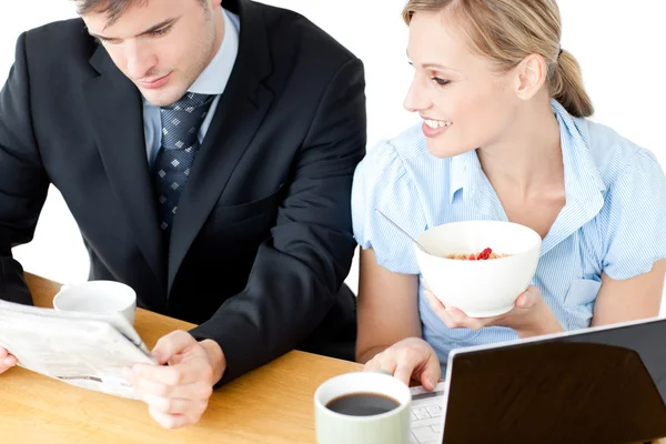 Happy couple of businesspeople having breakfast reading the news — Stock Photo, Image