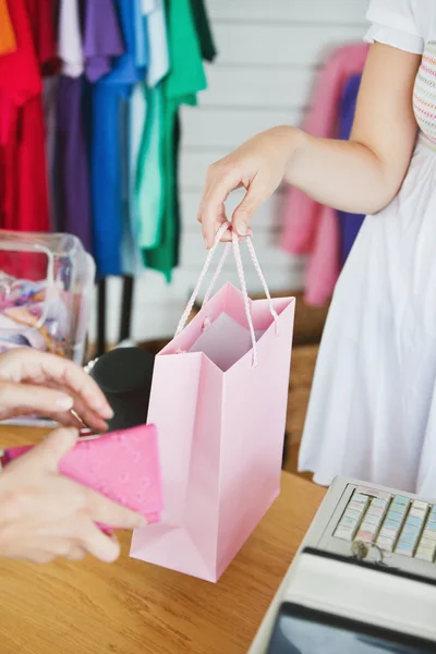 Caucasian saleswoman giving a shopping bag to a customer — Stock Photo, Image