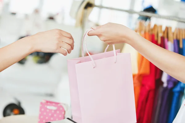 Försäljare ger en shopping väska till en kund — Stockfoto