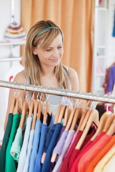 Bezaubernde junge Frau wählt ein farbenfrohes Hemd — Stockfoto